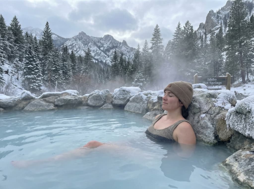 Soaking in a natural Idaho hot spring surrounded by snow-covered mountains